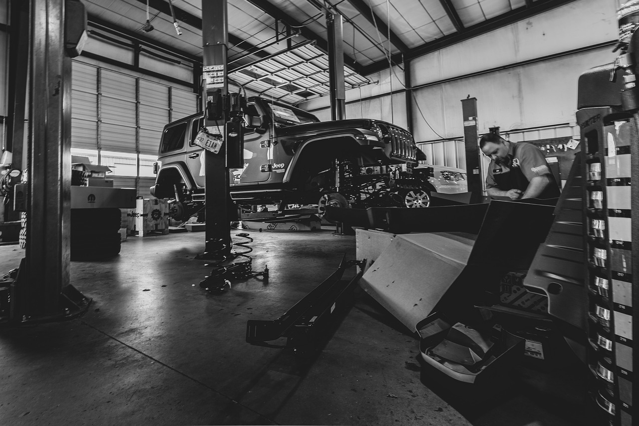 A Jeep inside a garage being worked on by a technician