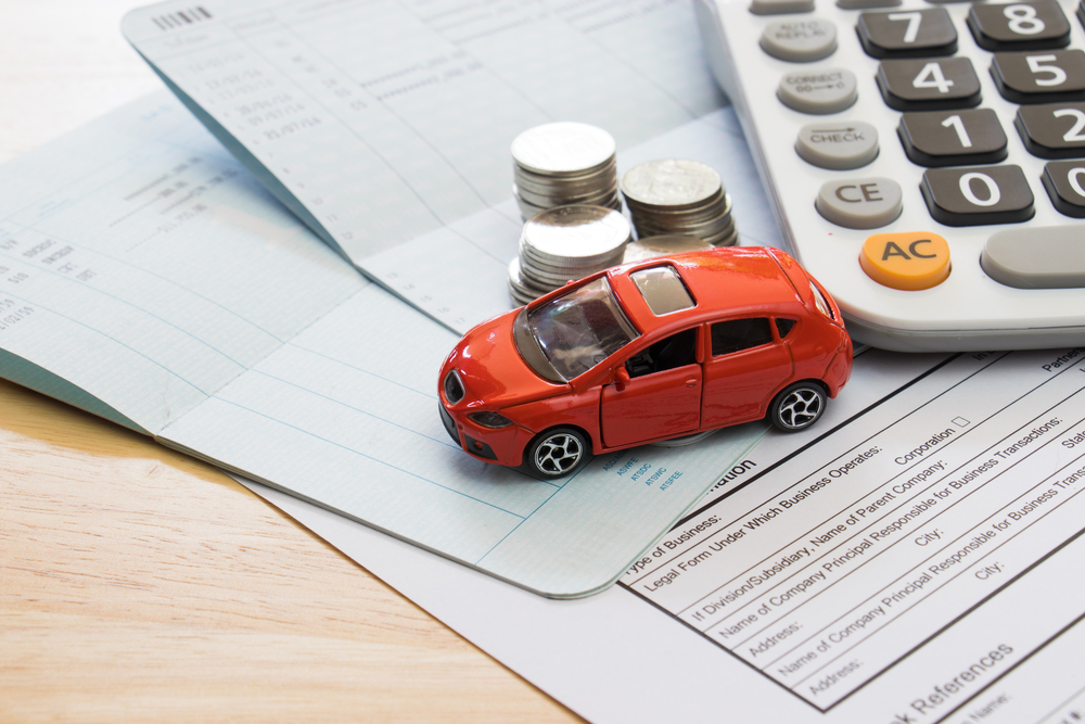 A small toy car on top of some accounting/finance paperwork
