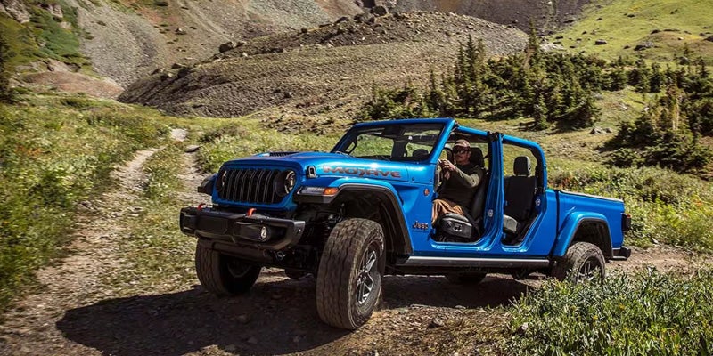 2026 Jeep Gladiator on a scenic mountain trail, ready for an adventurous summer road trip and outdoor exploration.